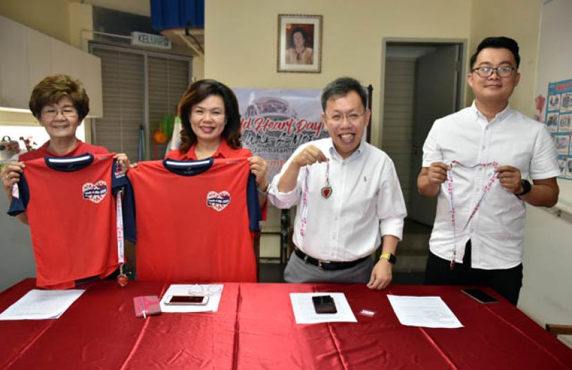 砂地方政府及房屋部长拿督沈桂贤（右二）与砂心脏基金及活动策划公司成员展示，将分发给已报名一公里步行活动者的T恤与心型纪念牌；左起为砂心脏基金财政拿督 李玉凤与秘书官淑琴，及右为活动策划公司Grid Event 创办人阿旺。