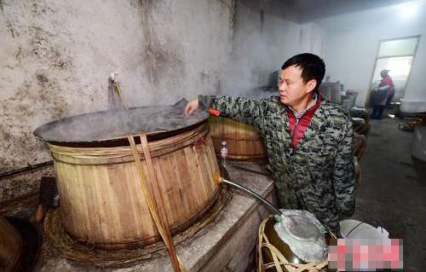 图示：村民在测试蒸馏锅冷却水水温。