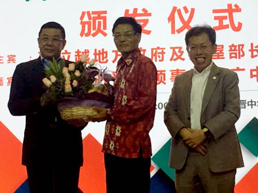 砂华文独中董联会署理会长拿督黄良杰（左）赠送水果礼篮予中国驻古晋总领事程广中，右为;砂地方政府与房屋部部长拿督沈桂贤。