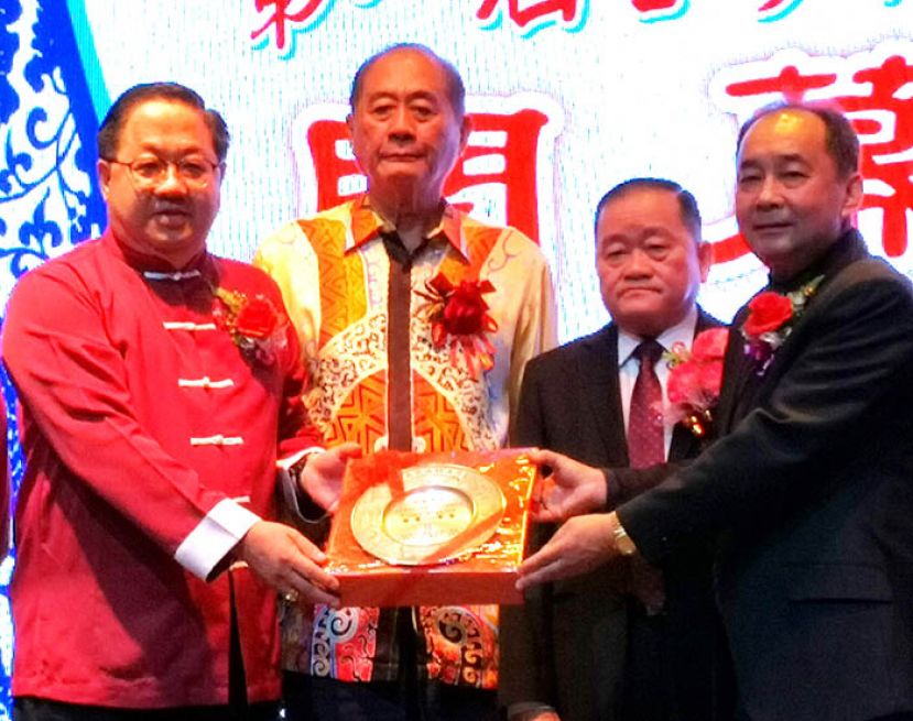 砂拉越福州乐龄（鹤龄）总会主席林唐锦（右一）代表赠送纪念品给诗巫闽清同乡会主席甲必丹刘贤远（左一）。左二是诗巫闽清同乡会名誉顾问张建卿，右二是马福总会长拿督斯里刘为强。