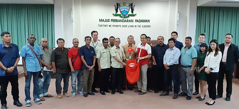 古晋冷藏（中央）有限公司总经理蔡明亮（右六）在巴达旺市议会副主席拿督阿末（右七）见证下移交公司赞助的围巾及帽子予斋戒月市集筹委会主席旺阿欣市议员（右八）。