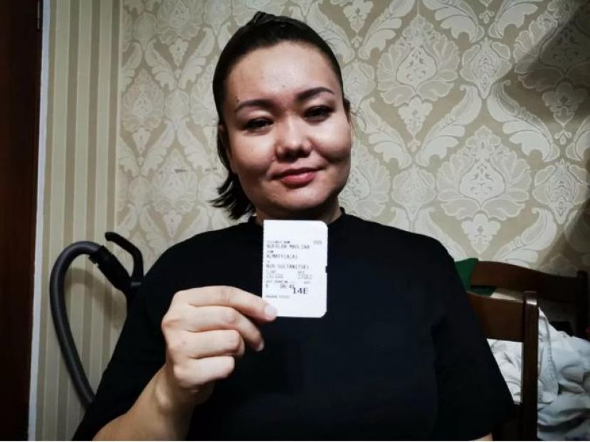 毛丽娜拿着险些夺去她性命的登机牌说，活着就一切都好。 图片来源：哈萨克斯坦新观察微信公众号